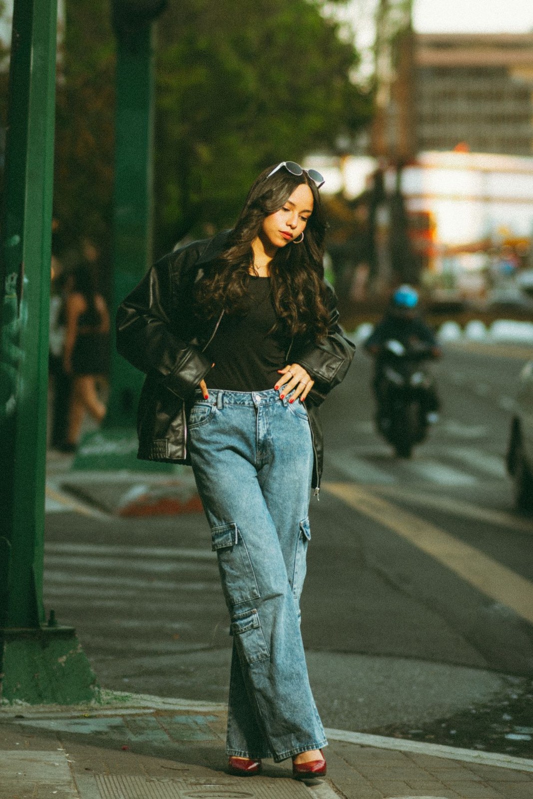 Black long-sleeve blouse and loose light-blue jeans with dark open-toe shoes.