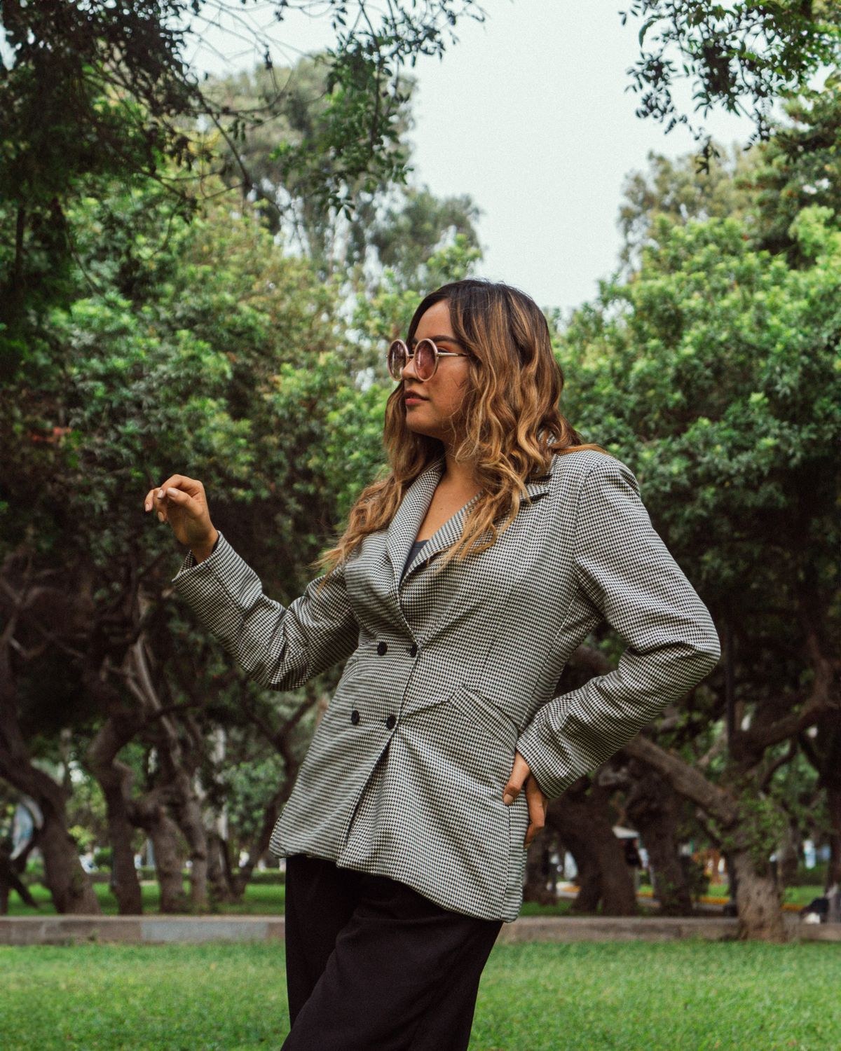 Fitted grey double-breasted blazer, dark trousers and glasses outdoors.