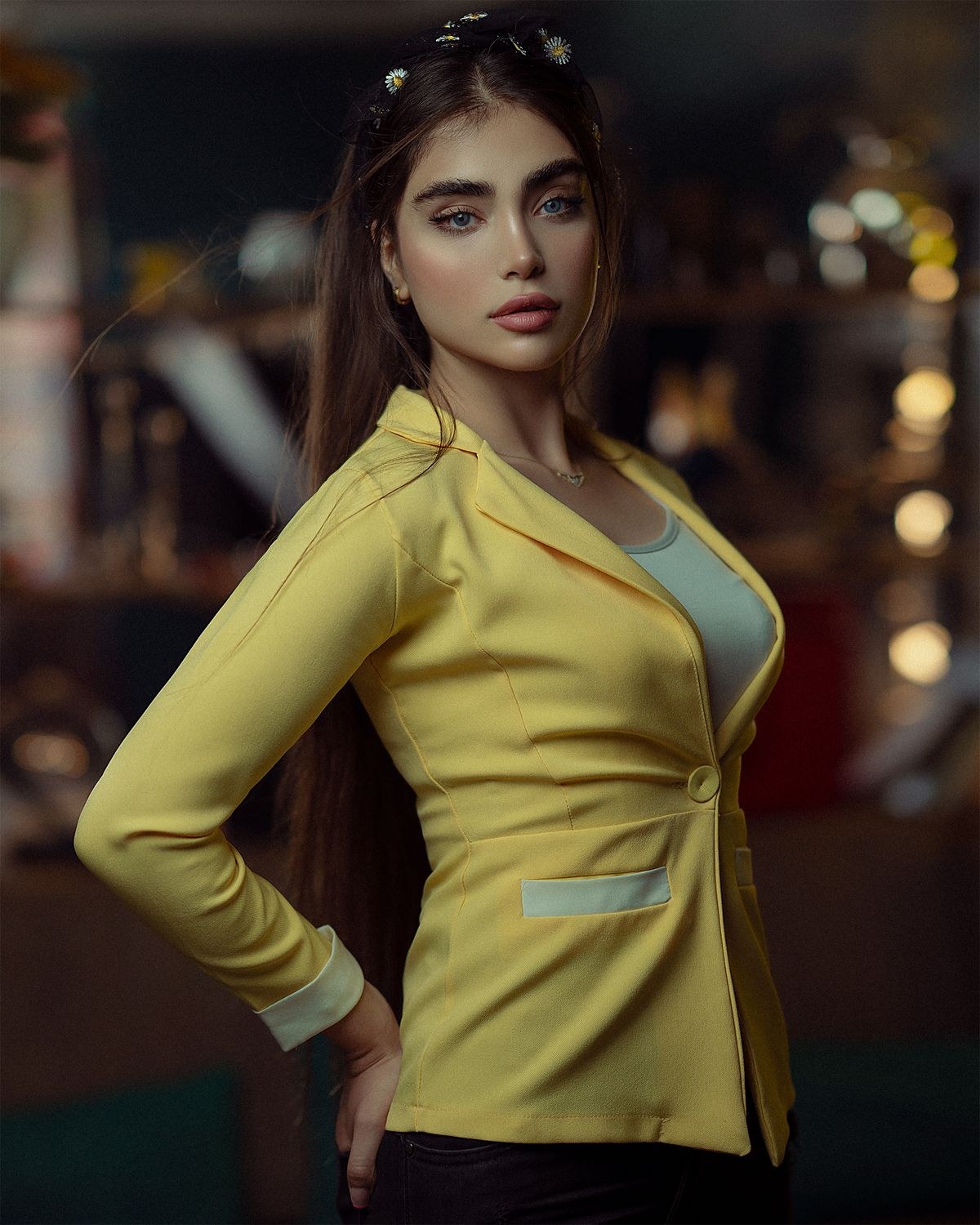 Yellow tailored blazer with contrasting piping over a teal top; portrait crop.