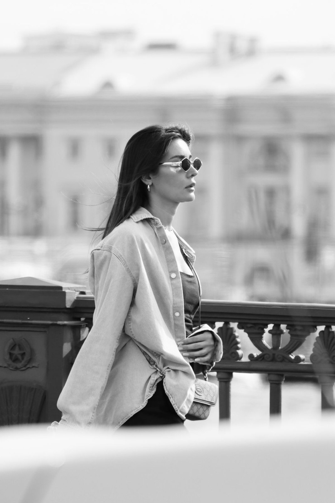 Black-and-white photo of a light blazer over a light top and dark trousers with sunglasses.