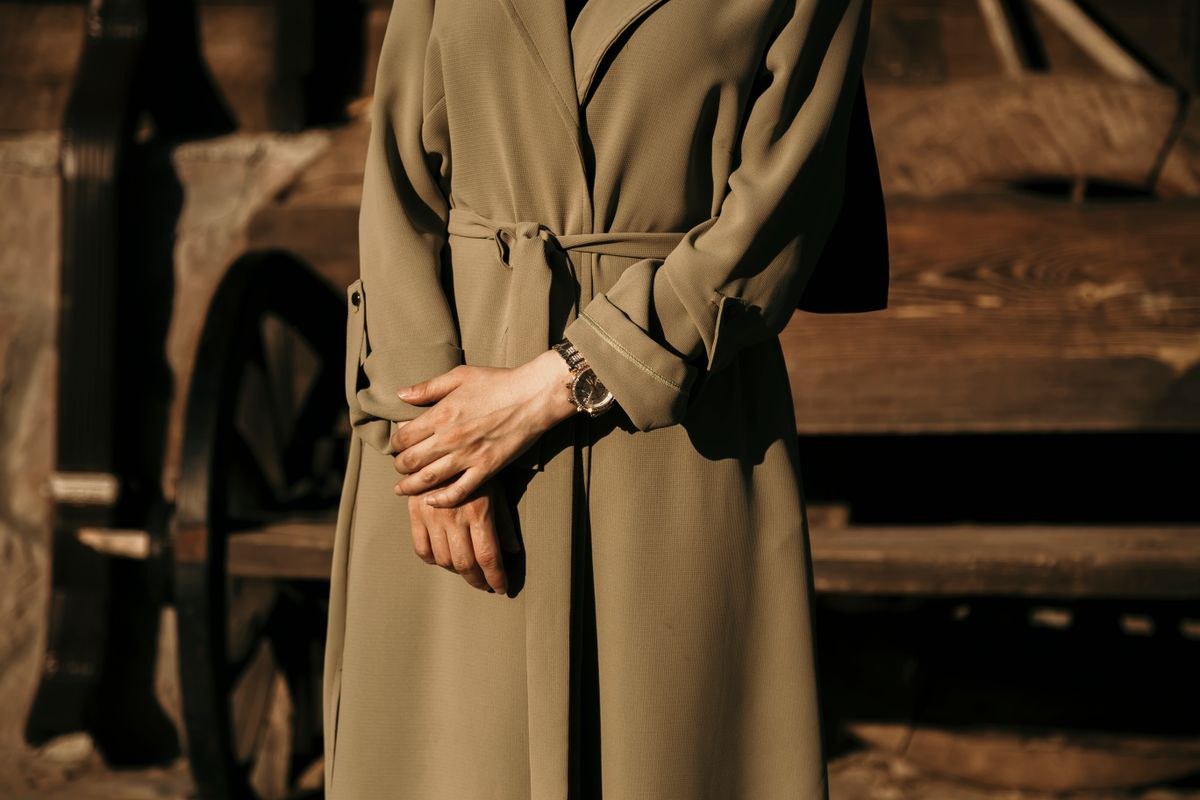 Olive long-sleeve belted dress with loose sleeves; cropped at the shoulders and lower skirt.