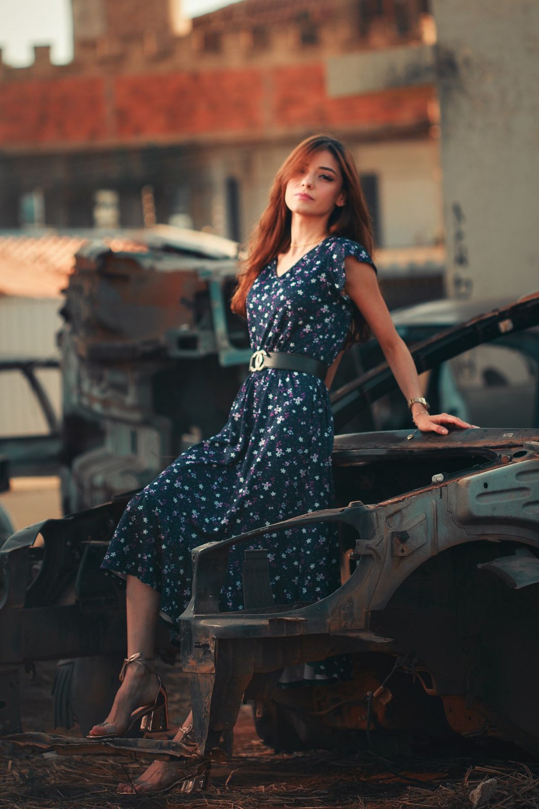 Sleeveless navy dress with white dots, a midi slit skirt and strappy heels.