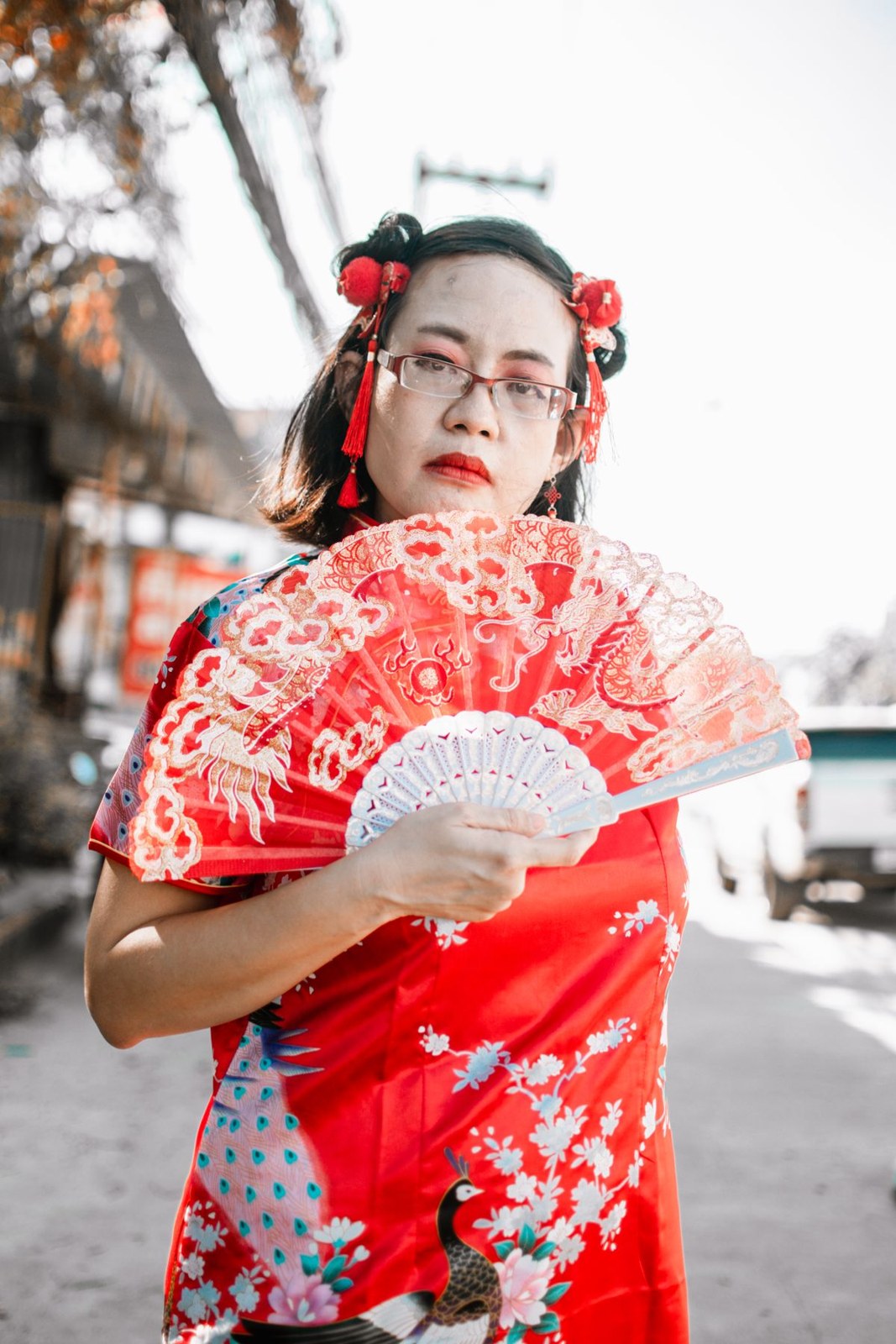 Red floral high-collar traditional dress, red fan, glasses and red hair ribbons.