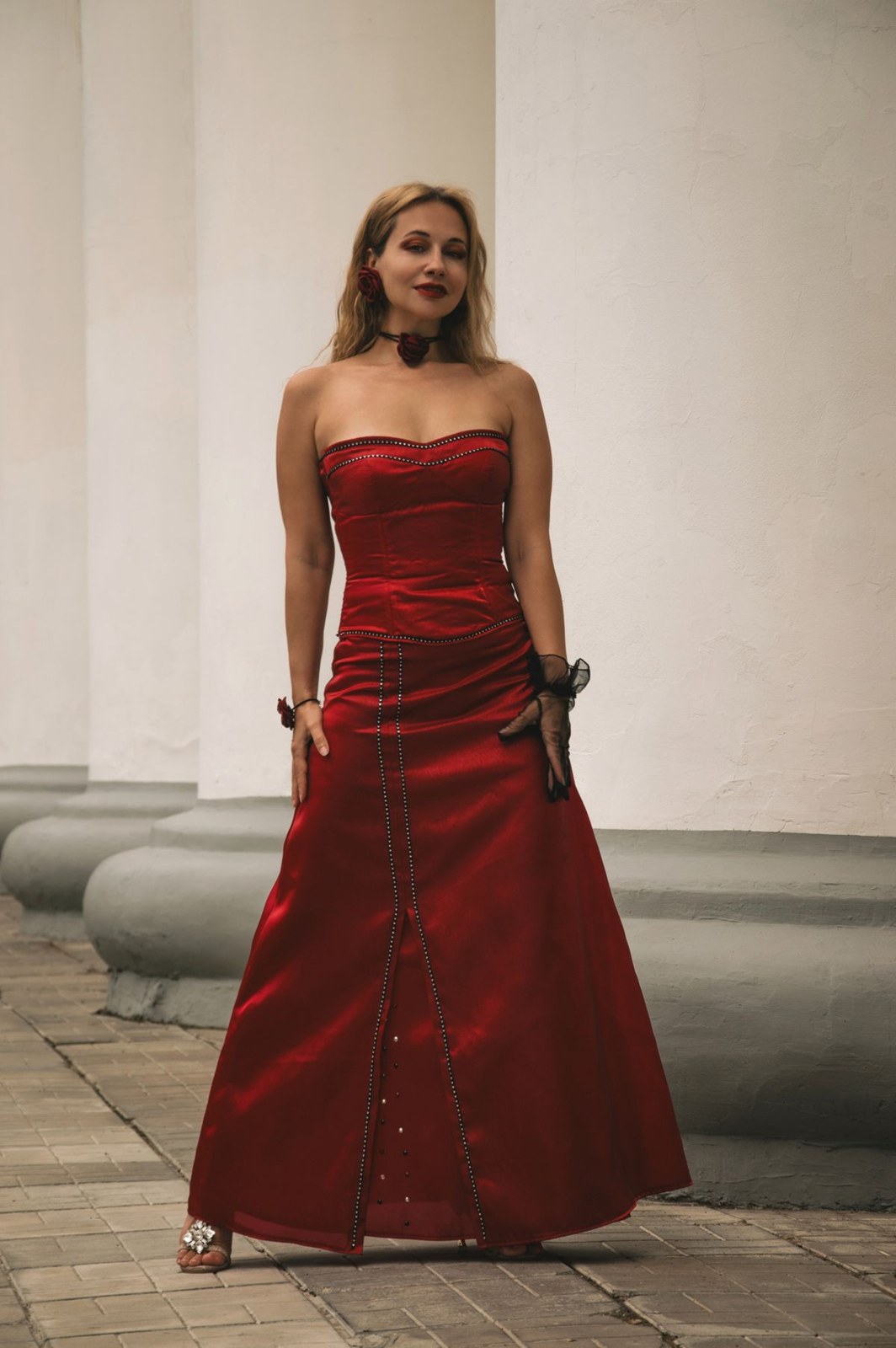 Long red strapless gown with a shaped neckline and small front buttons.