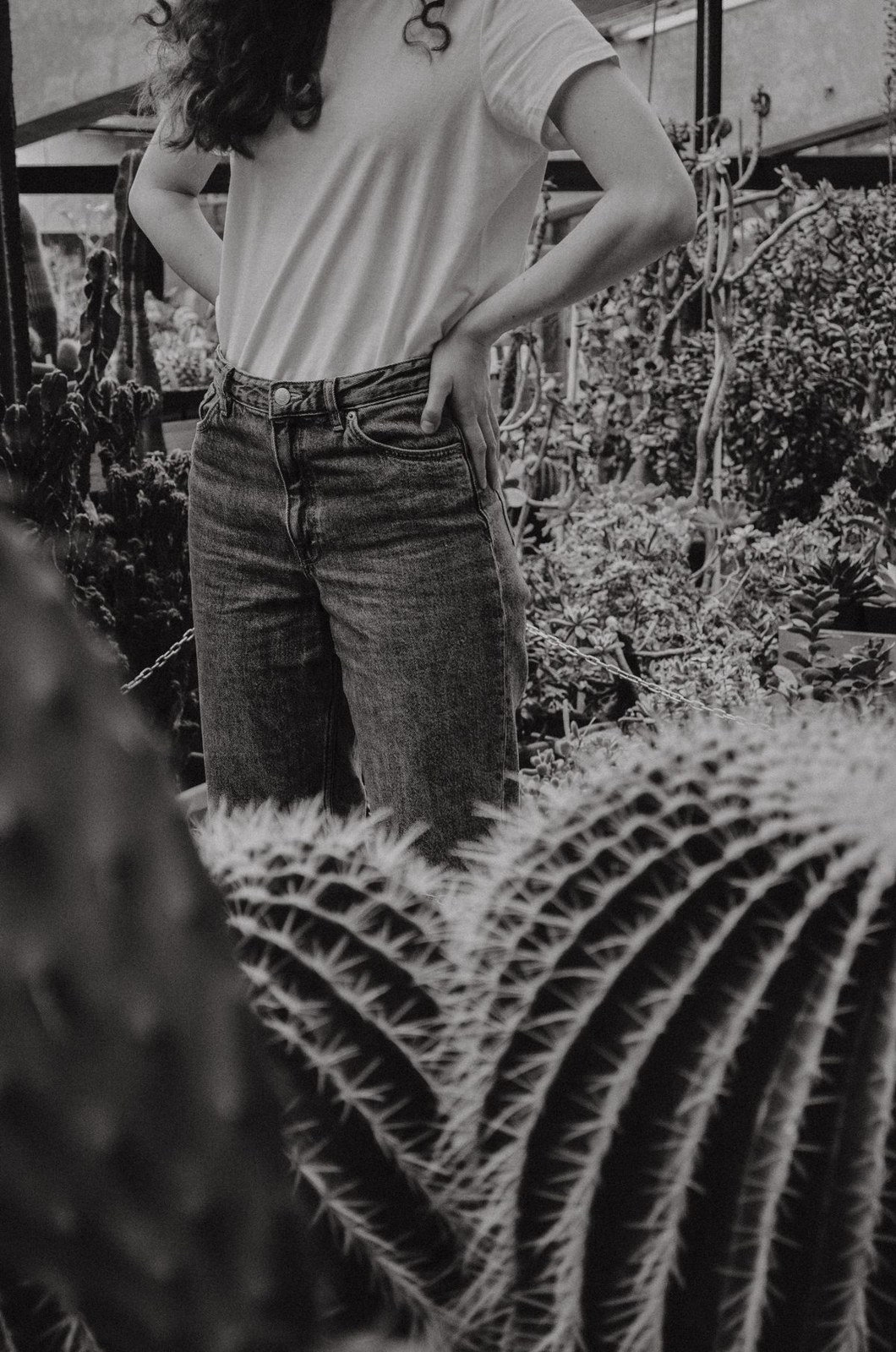 Schwarz-Weiß-Foto eines lockeren hellen T-Shirts in Jeans, Ausschnitt bis zur Hüfte.