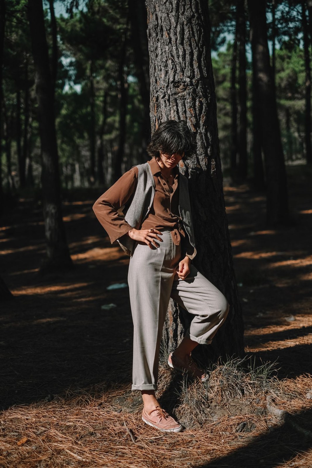Hellbrauner Blazer über heller Hemdbluse, helle weite Hose und nackte Füße im Wald.